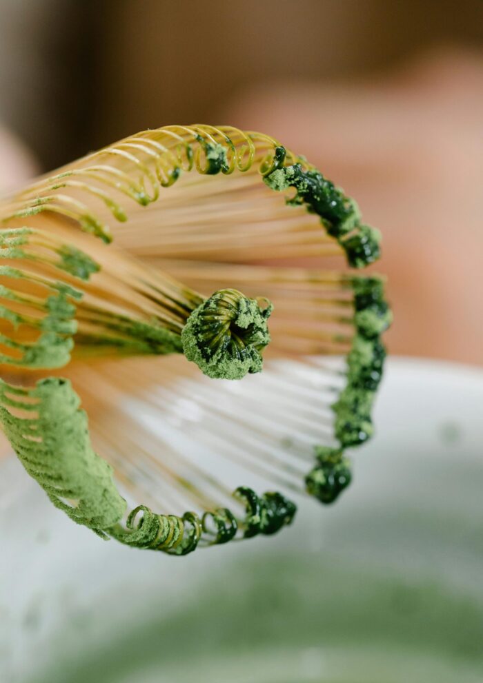 Detailed shot of a bamboo whisk used for preparing green matcha tea. Ideal for tea enthusiasts.